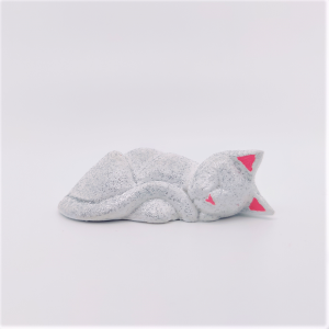 C'est un chat endormi, blanc pailleté argent avec un nez rose et l'intérieur des oreilles roses