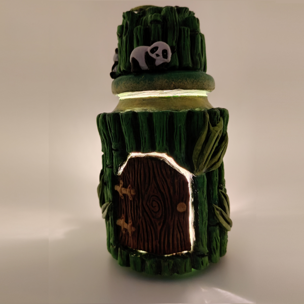 Maison de fée bambous et pandas. Photophore ou pot à trésors en verre recouvert d'argile peinte en différente teinte de vert, décoration de bambous et de panda sur le couvercle. Porte de fée en bois avec gong et poignée en doré